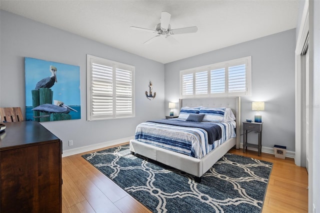 bedroom with ceiling fan, baseboards, and wood finished floors