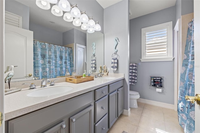 bathroom featuring toilet, tile patterned flooring, double vanity, and a sink