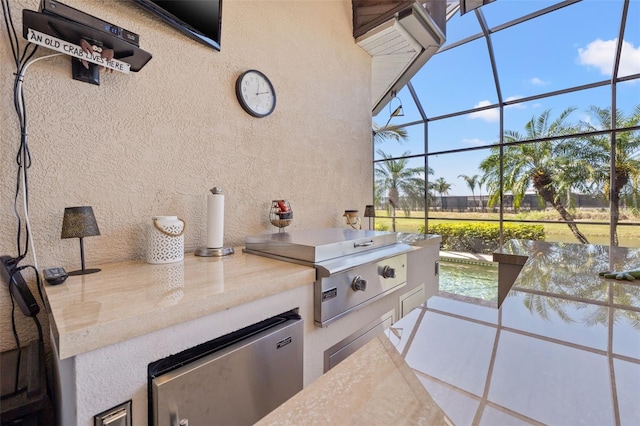 view of patio with a lanai, a grill, and an outdoor kitchen