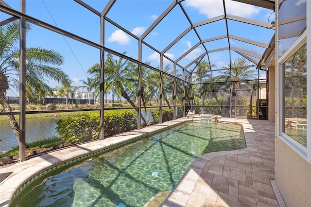 view of swimming pool featuring a patio, a water view, a lanai, and a pool with connected hot tub