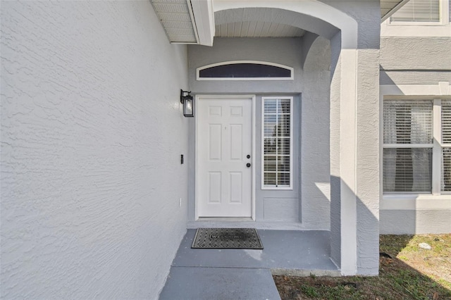 view of exterior entry featuring stucco siding