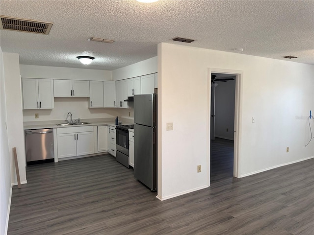 kitchen with white cabinetry, appliances with stainless steel finishes, dark wood-type flooring, and sink