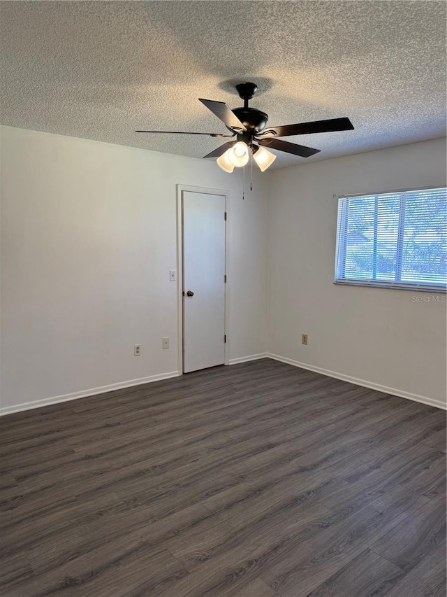 empty room featuring ceiling fan, dark wood-type flooring, and a textured ceiling