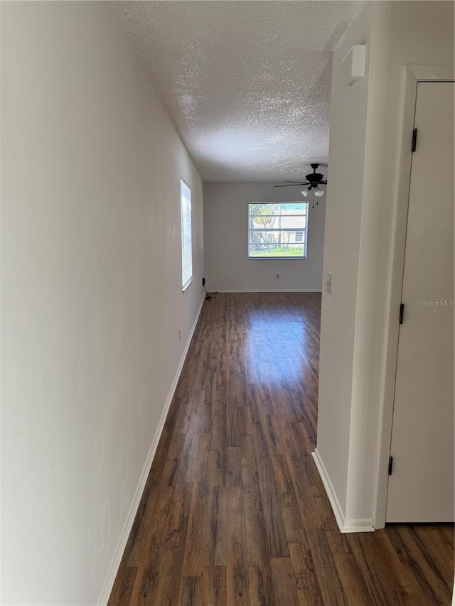 hallway featuring dark wood-type flooring and a textured ceiling