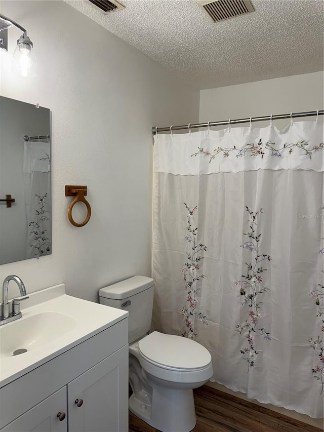 bathroom with hardwood / wood-style flooring, vanity, toilet, a textured ceiling, and a shower with shower curtain