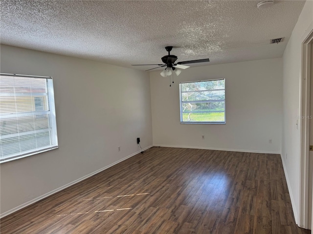 empty room featuring dark wood-type flooring, a textured ceiling, and ceiling fan