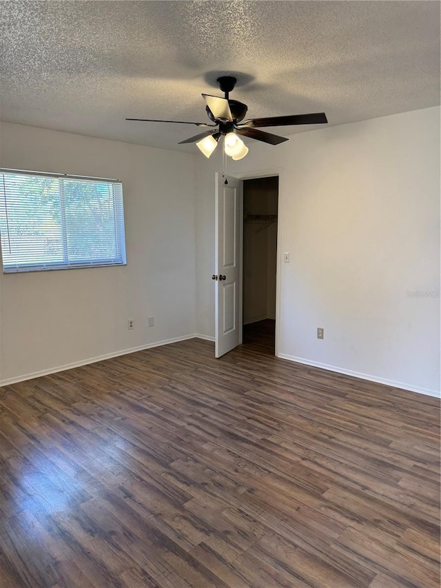 unfurnished bedroom with a closet, a textured ceiling, dark hardwood / wood-style floors, and ceiling fan