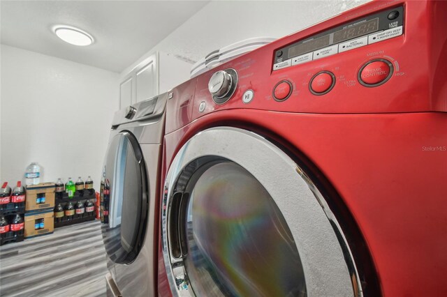 washroom with washer and clothes dryer and light wood-type flooring