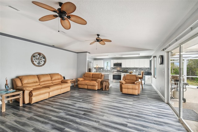 living room featuring vaulted ceiling, dark hardwood / wood-style floors, ceiling fan, and a textured ceiling