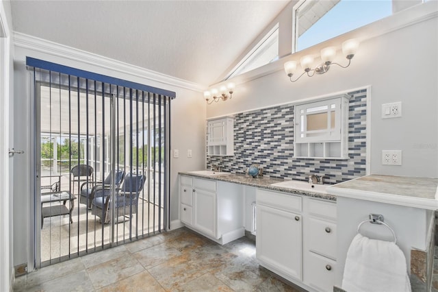 bathroom with vaulted ceiling, a textured ceiling, ornamental molding, vanity, and decorative backsplash