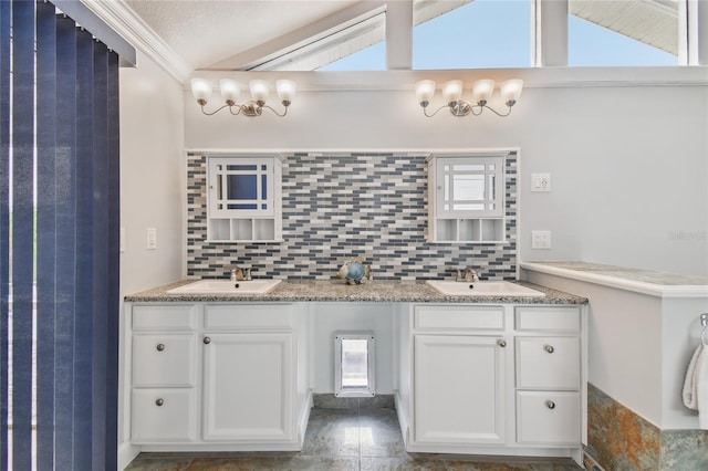 bathroom with lofted ceiling, vanity, and backsplash