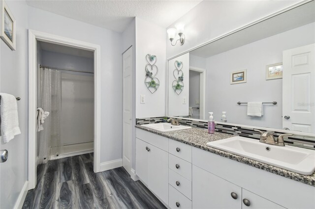 bathroom with vanity, hardwood / wood-style floors, a textured ceiling, and a shower with shower curtain