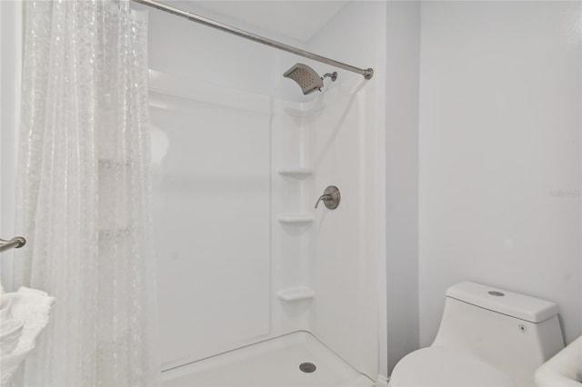 bathroom with toilet and a shower with curtain