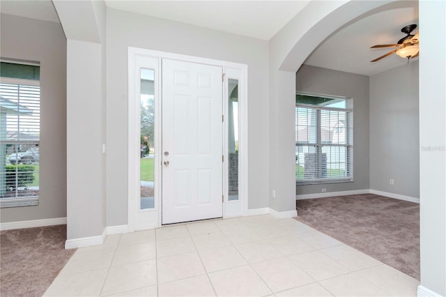 carpeted entrance foyer with ceiling fan and a wealth of natural light