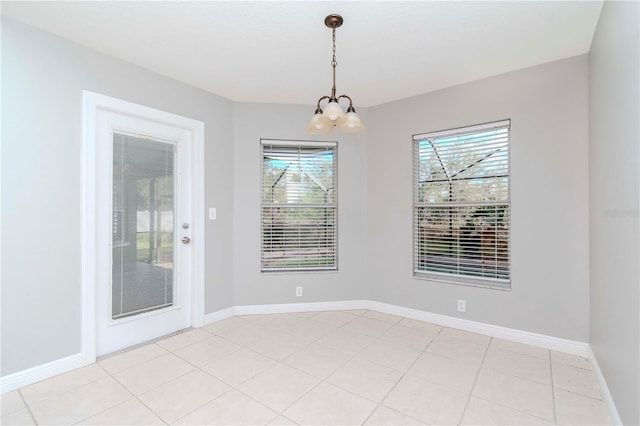 unfurnished dining area with an inviting chandelier and light tile patterned floors