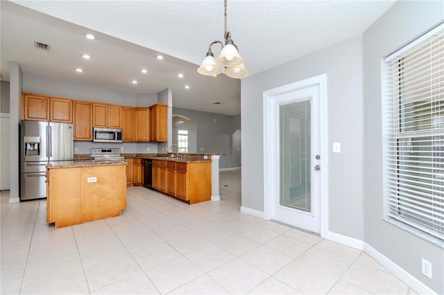 kitchen featuring appliances with stainless steel finishes, stone countertops, sink, hanging light fixtures, and kitchen peninsula