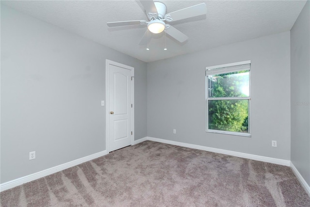 unfurnished room featuring ceiling fan, light colored carpet, and a textured ceiling