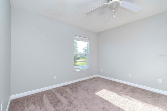 empty room featuring ceiling fan and light carpet