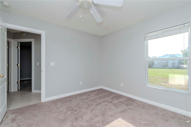 spare room with ceiling fan and light colored carpet