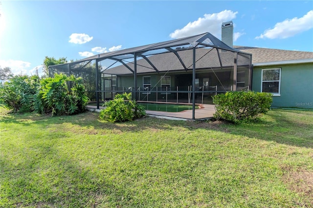 back of property with a lawn and glass enclosure