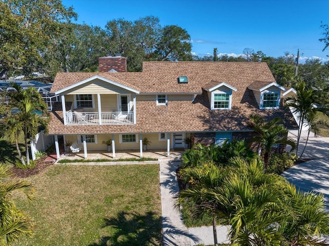 view of front of property with a balcony and a front lawn