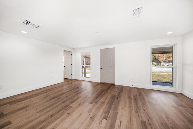 unfurnished room with wood-type flooring and a healthy amount of sunlight