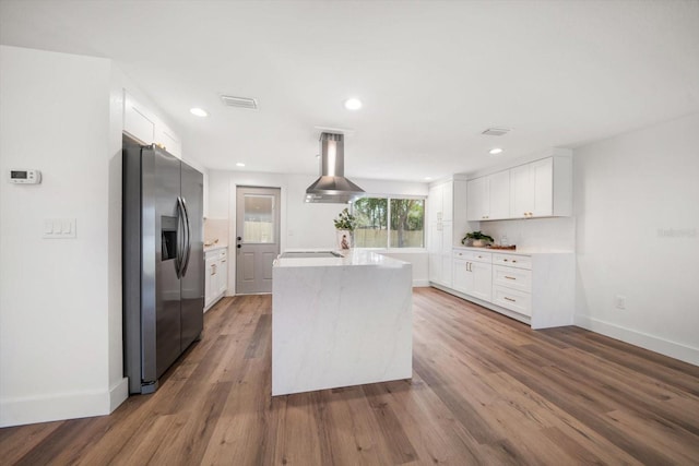 kitchen featuring a kitchen island, hardwood / wood-style floors, white cabinets, stainless steel fridge, and island exhaust hood