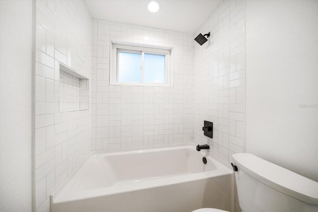 bathroom with tiled shower / bath combo and toilet