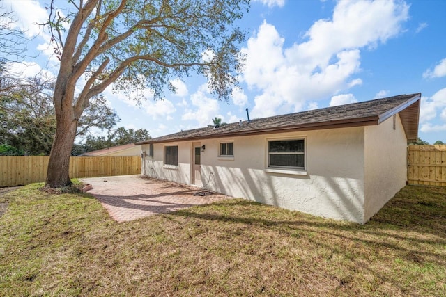 rear view of house featuring a yard and a patio area