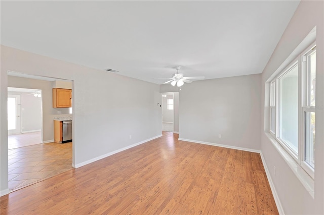 unfurnished room with a ceiling fan, baseboards, visible vents, and light wood-style floors