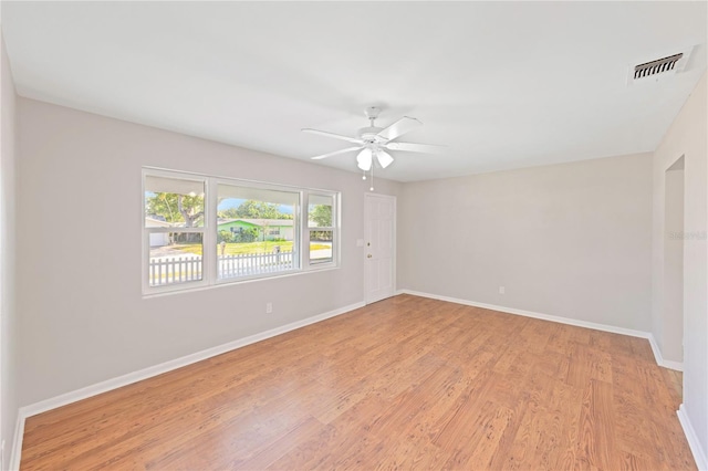spare room with visible vents, a ceiling fan, light wood-style floors, and baseboards