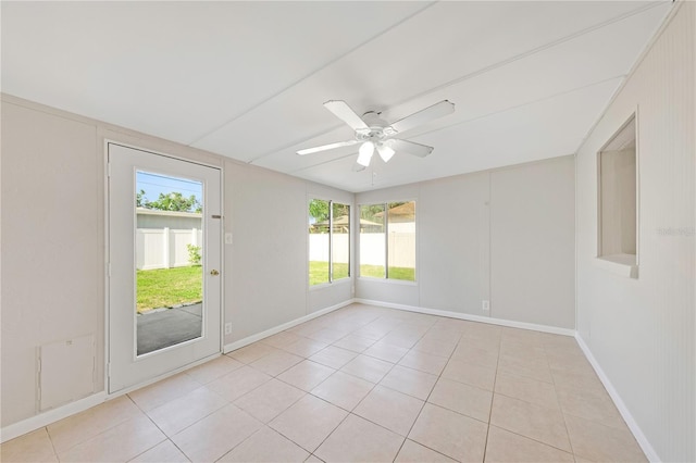spare room featuring plenty of natural light, baseboards, ceiling fan, and light tile patterned floors