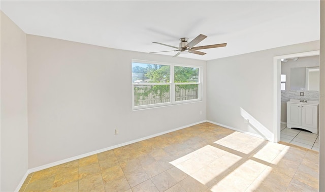 unfurnished bedroom with baseboards, a ceiling fan, and ensuite bath