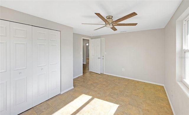 unfurnished bedroom featuring baseboards, stone finish flooring, visible vents, and a closet