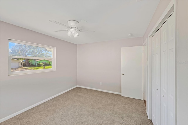 unfurnished bedroom featuring a closet, baseboards, a ceiling fan, and carpet flooring