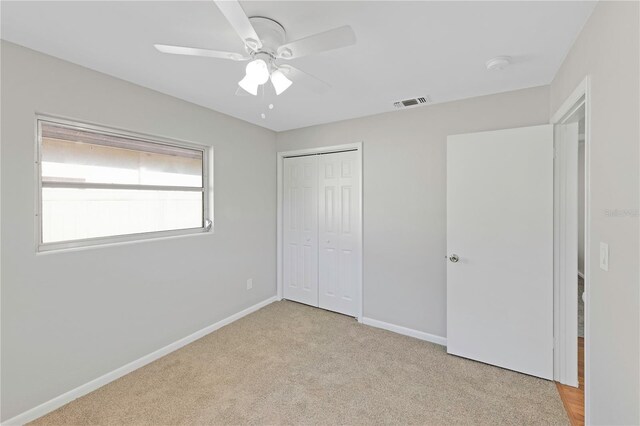 unfurnished bedroom with visible vents, carpet floors, a closet, baseboards, and a ceiling fan