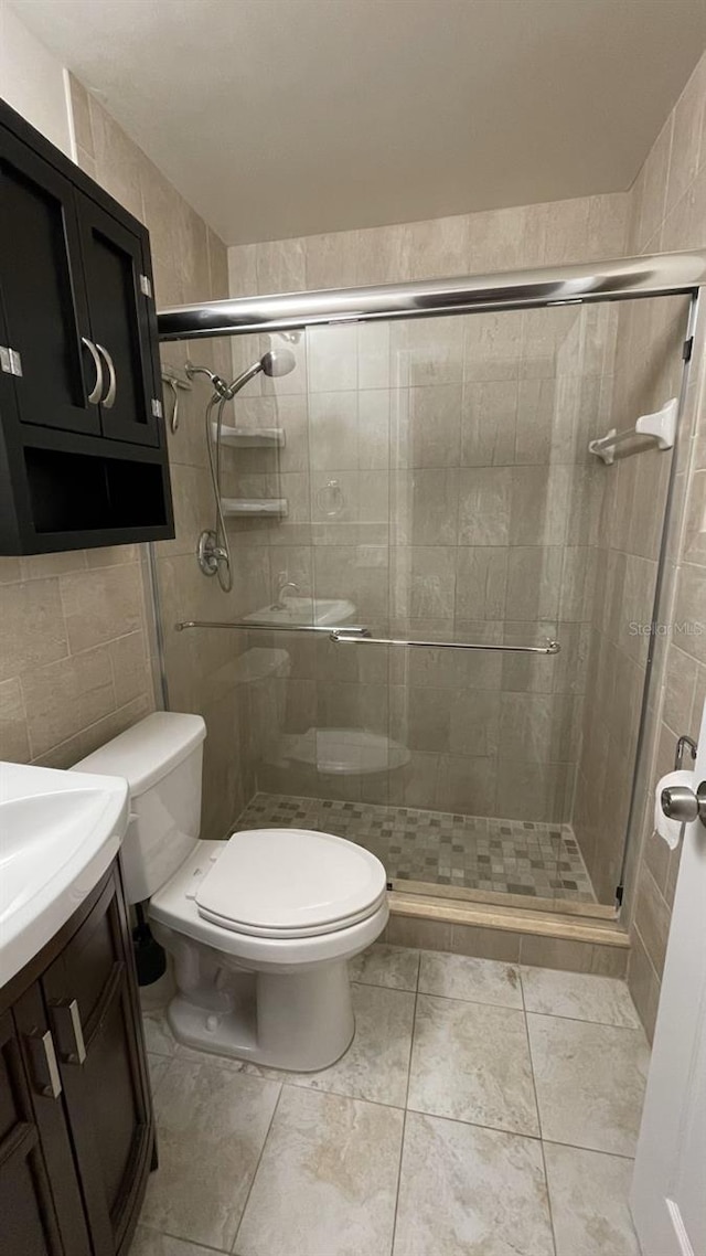 bathroom with vanity, tile walls, an enclosed shower, and toilet