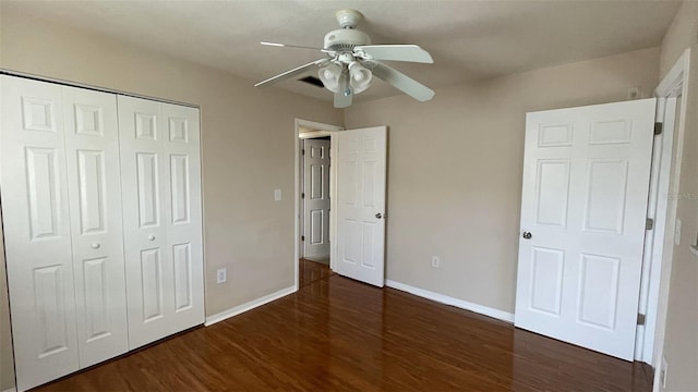 unfurnished bedroom with ceiling fan, dark hardwood / wood-style flooring, and a closet