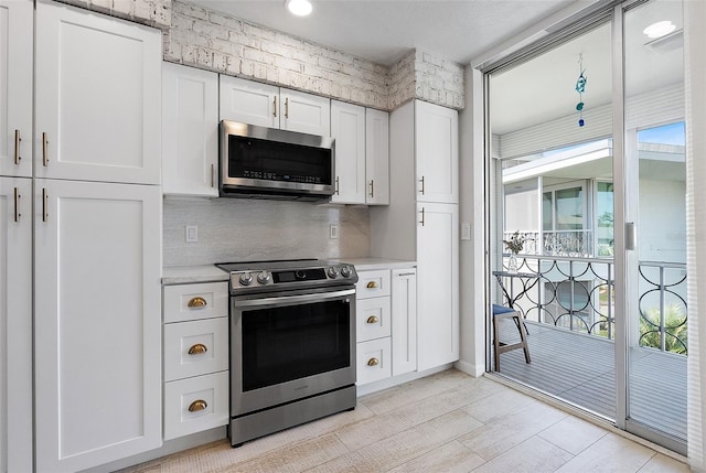 kitchen featuring light wood-style flooring, white cabinetry, stainless steel appliances, and decorative backsplash