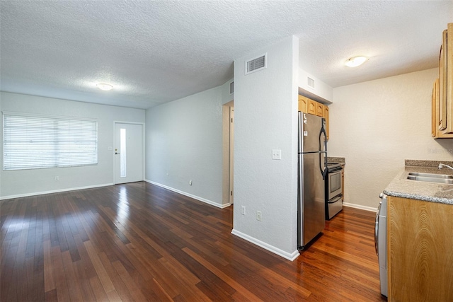 kitchen featuring dark wood-style floors, visible vents, stainless steel appliances, and a sink