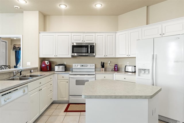 kitchen featuring white appliances, light countertops, a sink, and light tile patterned floors