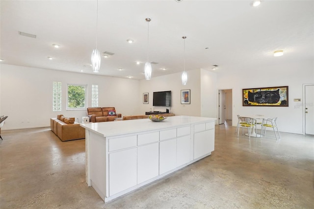 kitchen with hanging light fixtures, white cabinetry, and a kitchen island