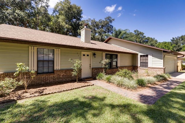 ranch-style house featuring a garage and a front lawn