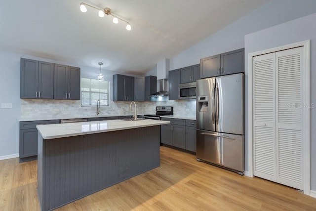 kitchen with lofted ceiling, sink, a kitchen island with sink, hanging light fixtures, and stainless steel appliances