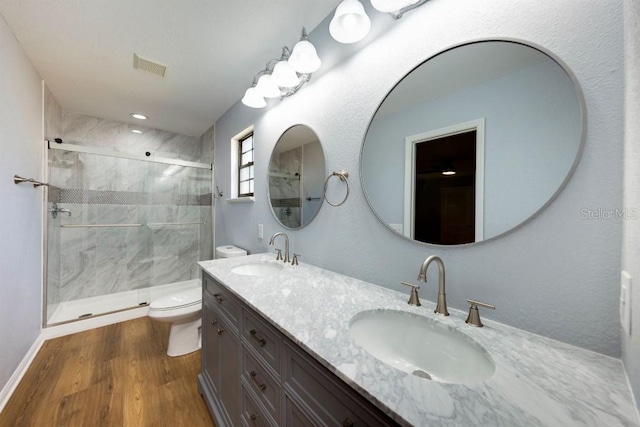 bathroom with vanity, wood-type flooring, toilet, and walk in shower