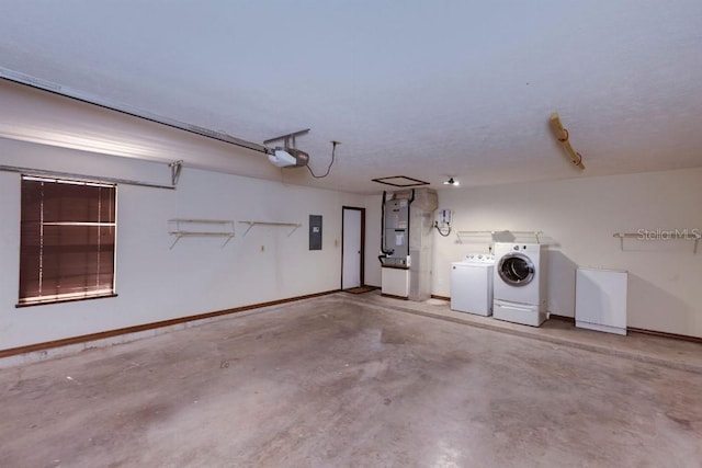 garage featuring heating unit, a garage door opener, electric panel, and washer and dryer