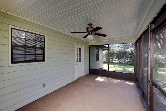 unfurnished sunroom featuring ceiling fan