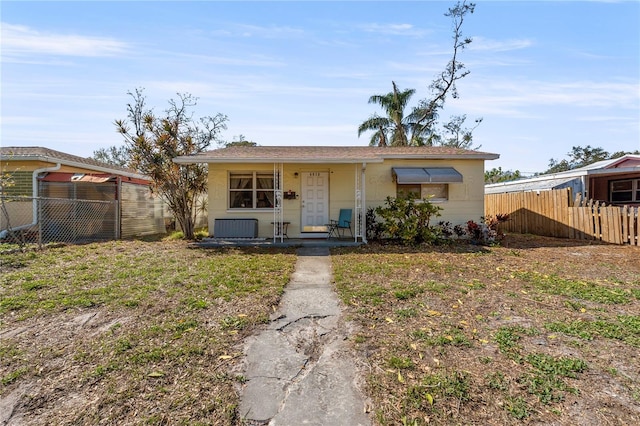 view of front of house with a front lawn, fence, and stucco siding