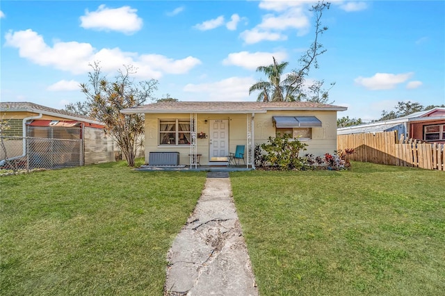 view of front of home with a front yard, fence, covered porch, and stucco siding