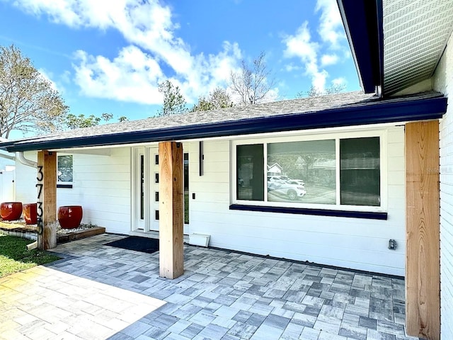 exterior space featuring a patio and roof with shingles